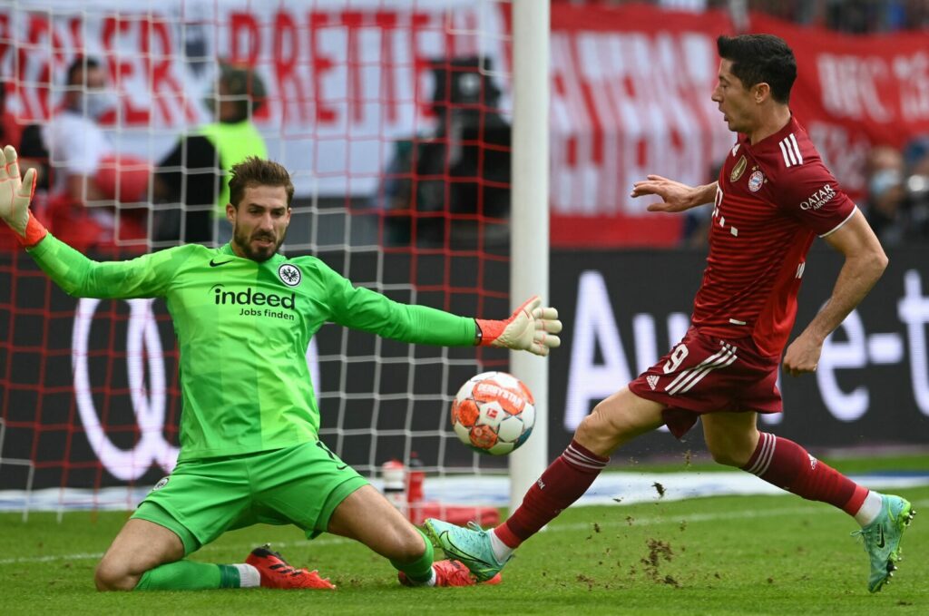 Torhüter Kevin Trapp von Eintracht Frankfurt (links) pariert einen Abschluss von Robert Lewandowski (rechts) vom FC Bayern München im Hinspiel der aktuellen Bundesliga-Saison