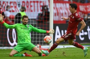 Torhüter Kevin Trapp von Eintracht Frankfurt (links) pariert einen Abschluss von Robert Lewandowski (rechts) vom FC Bayern München im Hinspiel der aktuellen Bundesliga-Saison