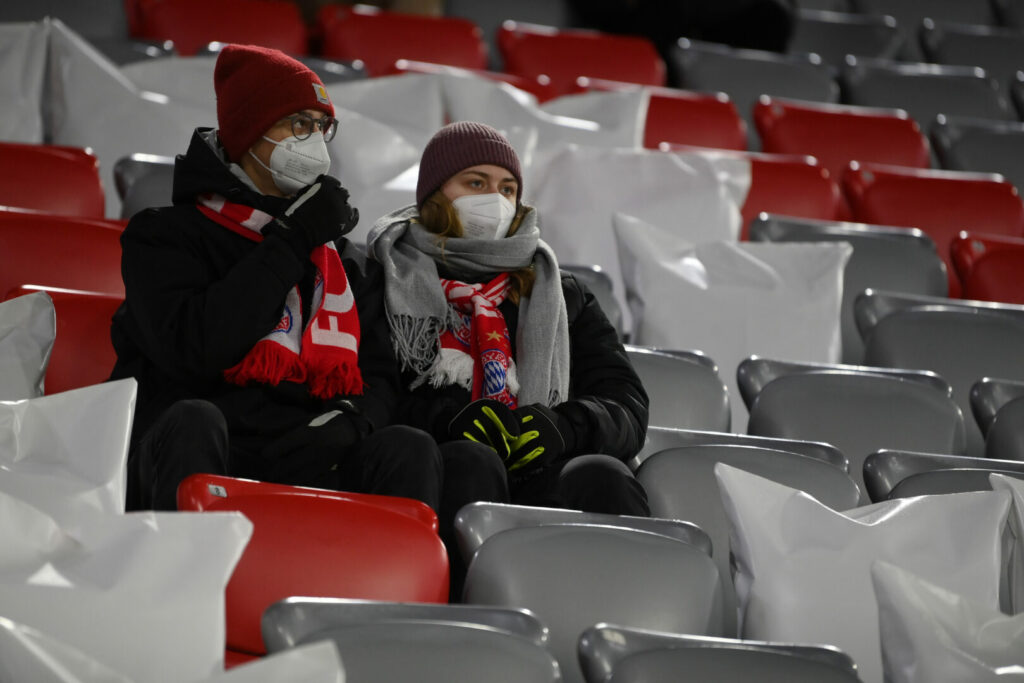 Stadion in Bayern, zwei Zuschauer mit Maske
