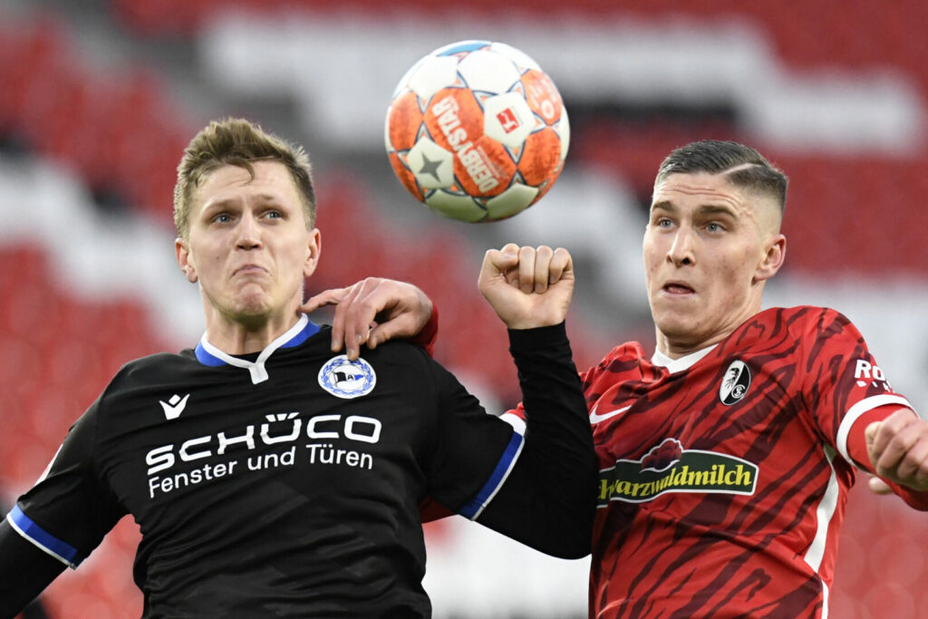 Joakim Nilsson (links) kämpft für Arminia Bielefeld mit Freiburgs Roland Sallai um den Ball.