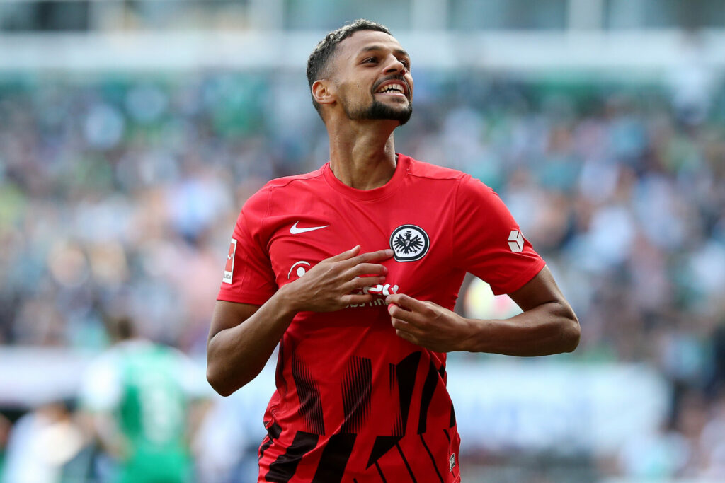 Djibril Sow zeigt auf das Logo von Eintracht Frankfurt. Der Mittelfeldspieler wird wohl vorerst bleiben.