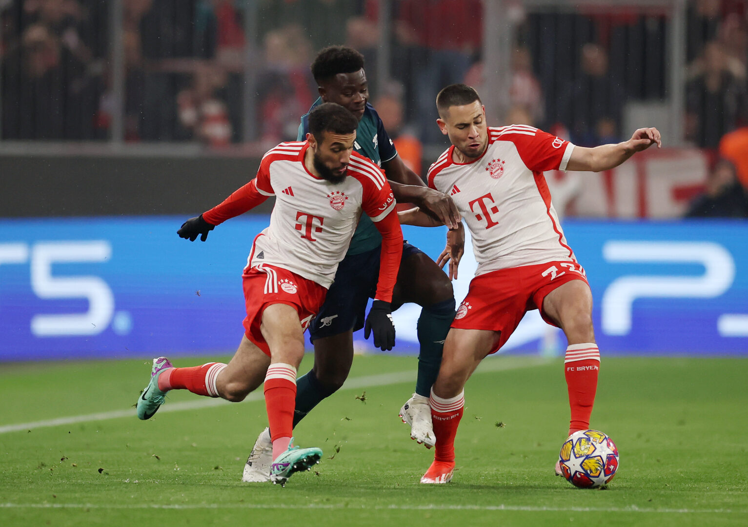 Noussair Mazraoui und Raphael Guerreiro im Trikot des FC Bayern nehmen Arsenals Bukayo Saka in die Zange