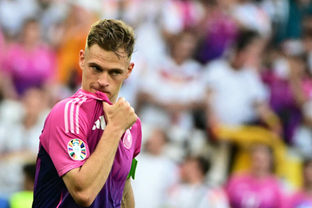 Joshua Kimmich beißt nachdenklich in das pinke Trikot Deutschlands bei der EM 2024.