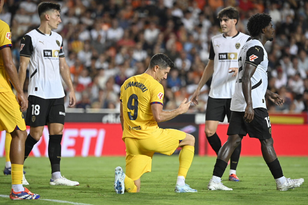 Matchwinner Robert Lewandowski kniet im Trikot des FC Barcelona (Mi.) und feiert den Sieg in Valencia.