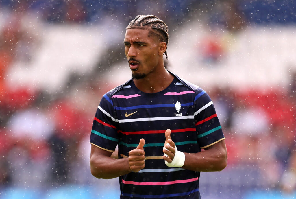 Loic Bade im Aufwärmtrikot der französischen Nationalmannschaft, er pustet durch und klatscht in die Hände.