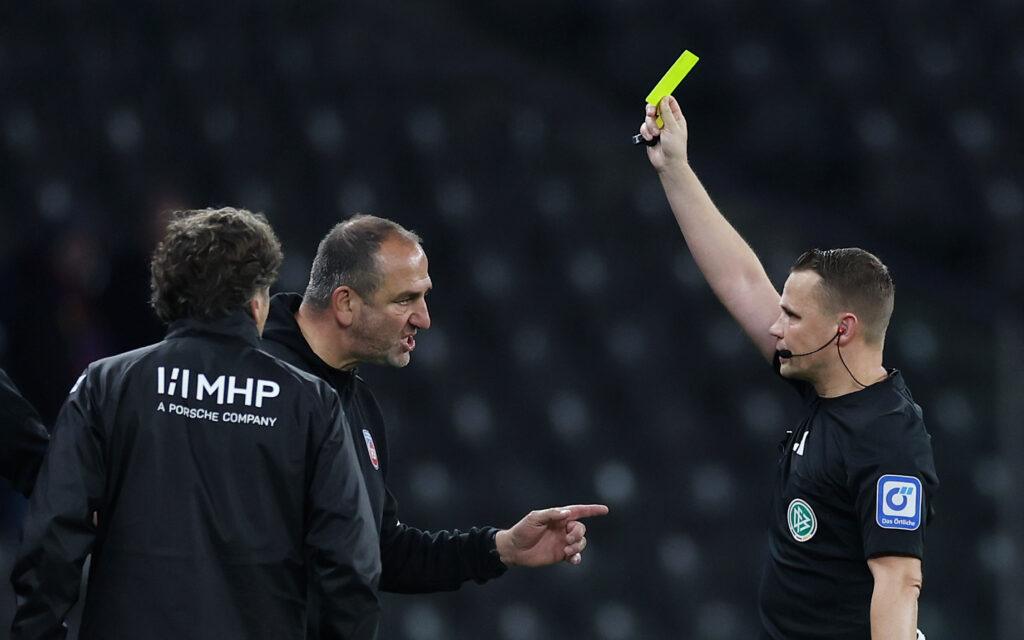 Heidenheims Trainer Frank Schmidt (Mi.) war wegen der Entscheidung von Schiedsrichter Robert Kampka (re.) in letzter Minute gegen Hertha BSC außer sich und sah Gelb