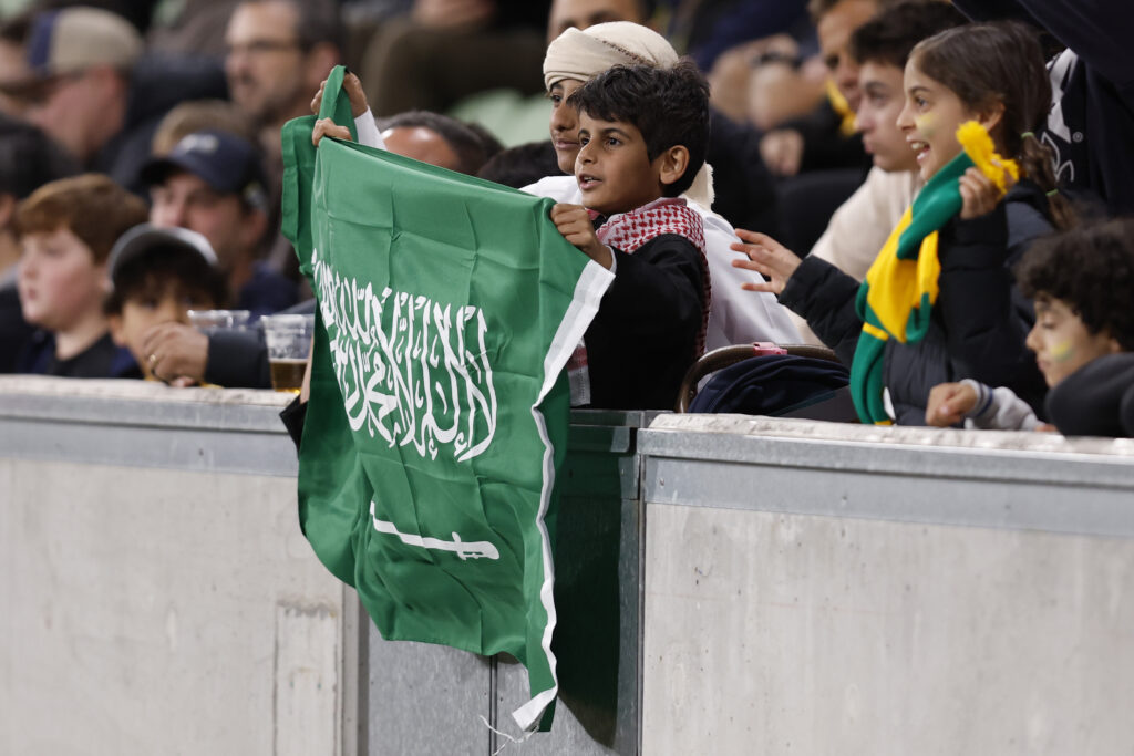 Ein Kind präsentiert stolz die Flagge von Saudi-Arabien