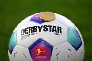 Eine Schoko-Münze liegt auf dem Bundesliga-Ball
