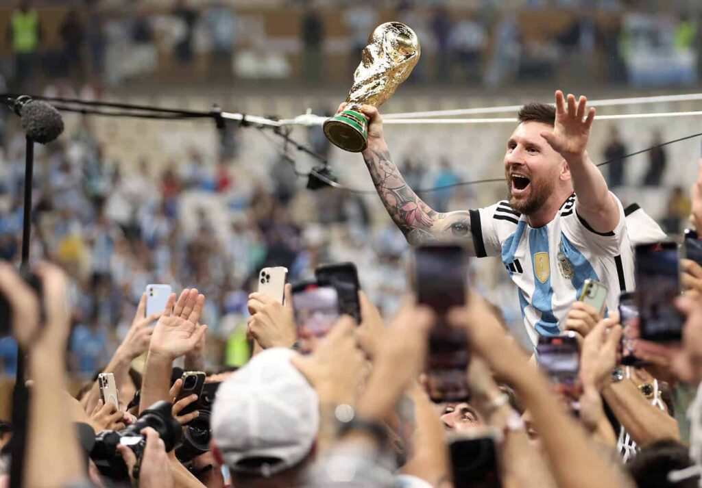 Lionel Messi mit dem WM-Pokal in einer Menschenmasse