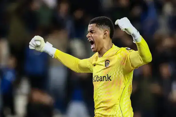 Lucca Brughmans, Genk goalkeeper in a yellow kit, shouting and celebrating with arms raised